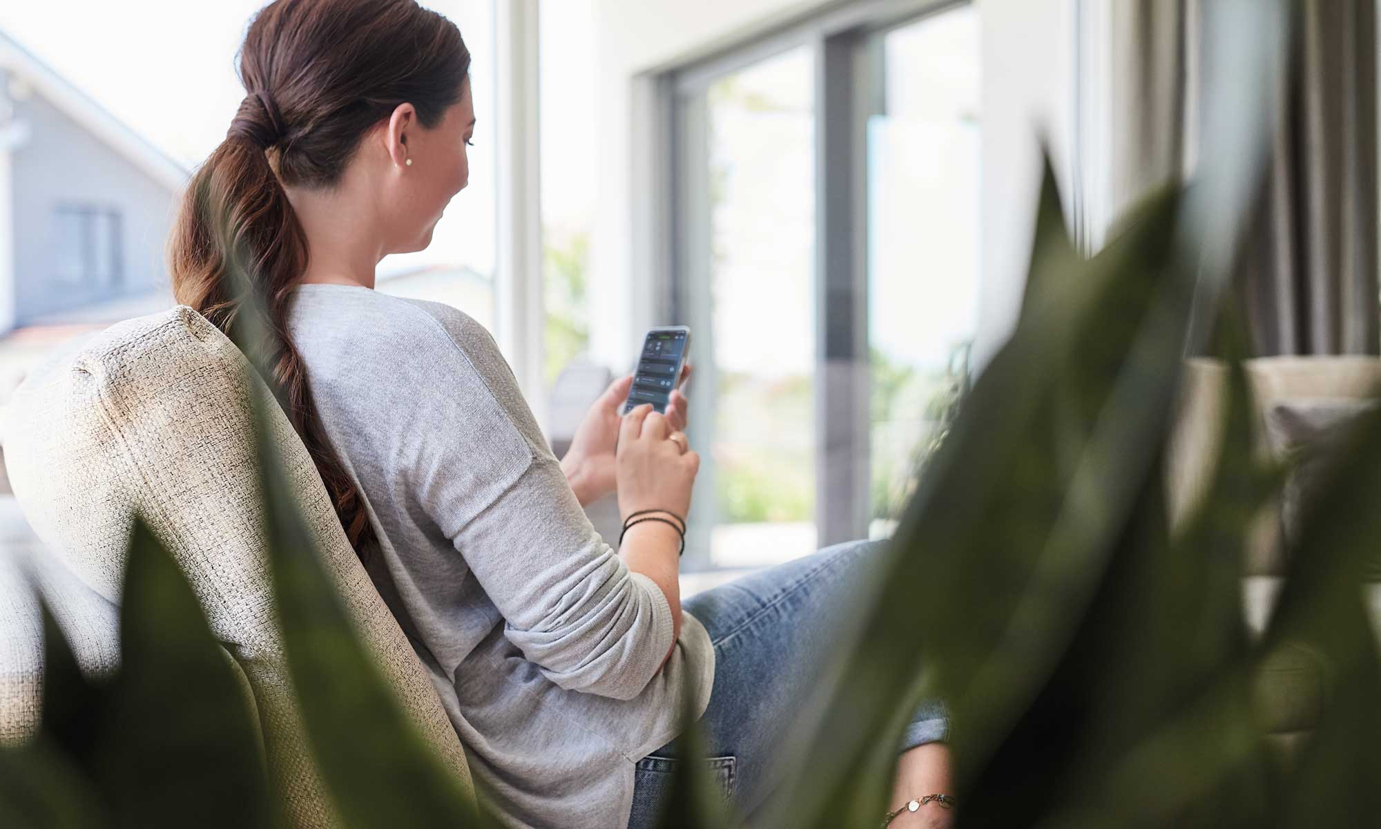 Person am Smartphone Musterhaus Vita von Fertighaus WEISS