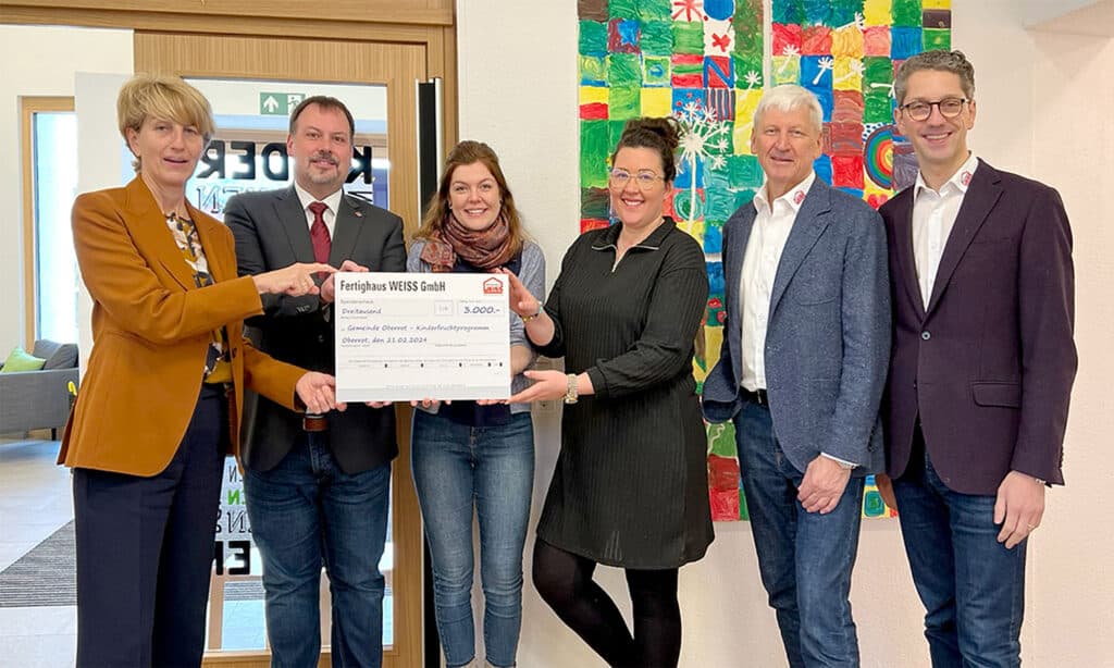 Die Geschäftsleitung von Fertighaus WEISS übergibt einen Spendenscheck an die Gemeinde Oberrot und die Leitung der Kindertagesstätte